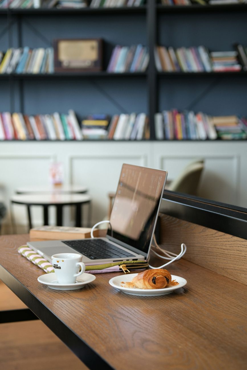 cozy cafe workspace with laptop and pastry